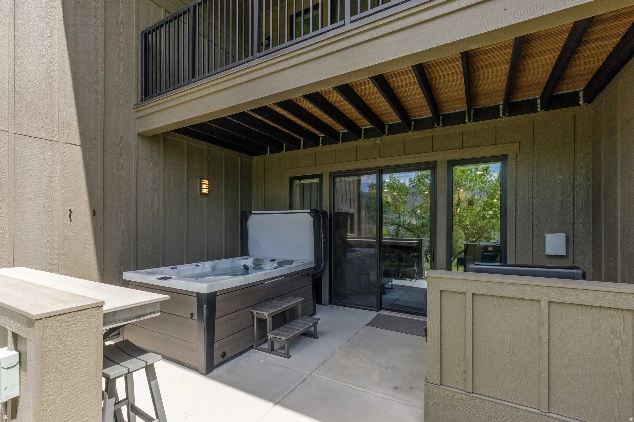 Private patio featuring a built-in hot tub with steps, an outdoor bar counter, and direct access through sliding glass doors