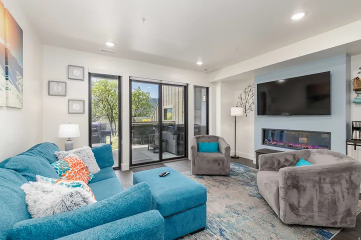 Open living area featuring wood-finish flooring, recessed lighting, and a contemporary linear fireplace