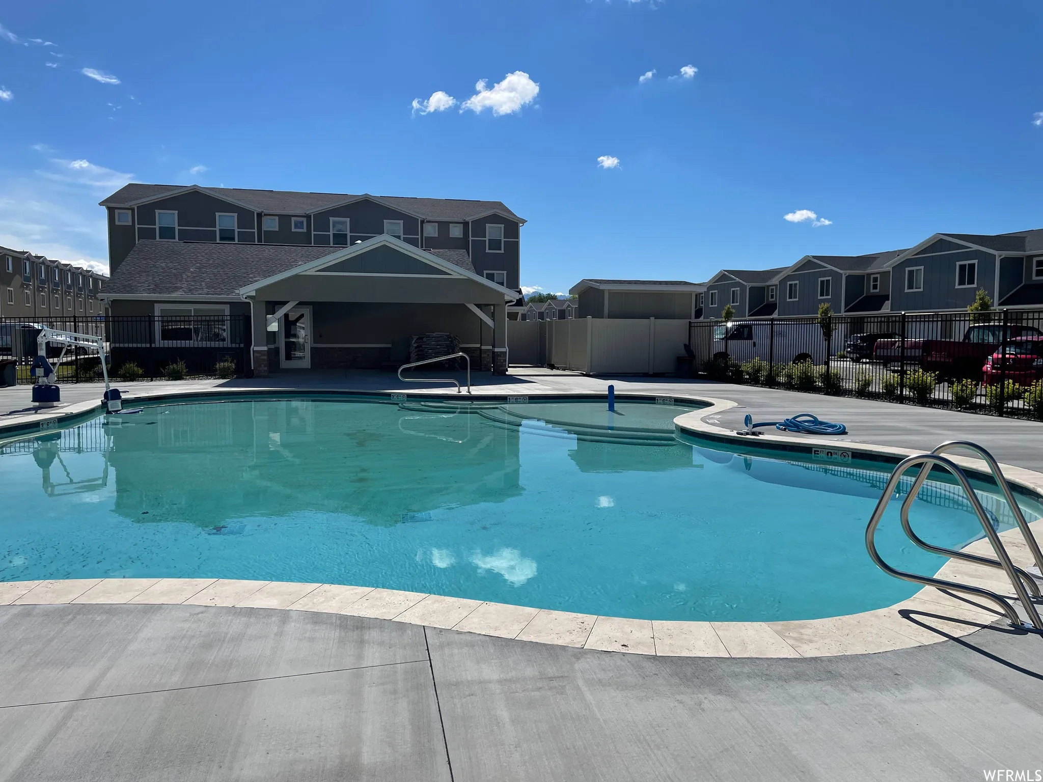Freeform swimming pool with concrete decking and a light-colored coping