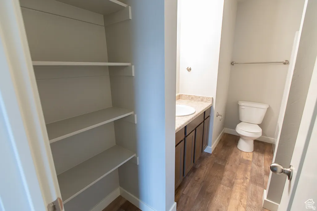 Bathroom featuring a vanity with dark wood-finish cabinetry, a light speckled countertop, and an undermount sink