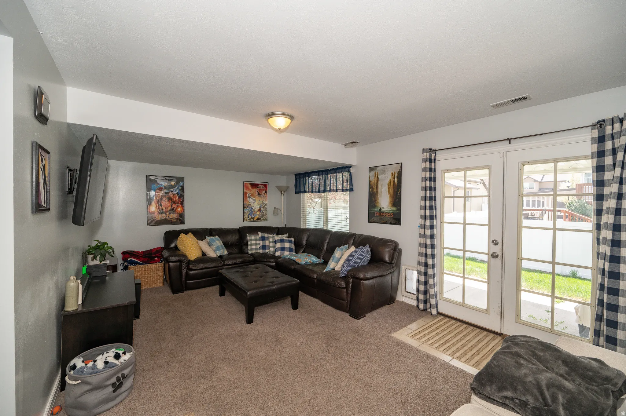 Versatile lower-level living space featuring neutral carpet flooring and light gray walls
