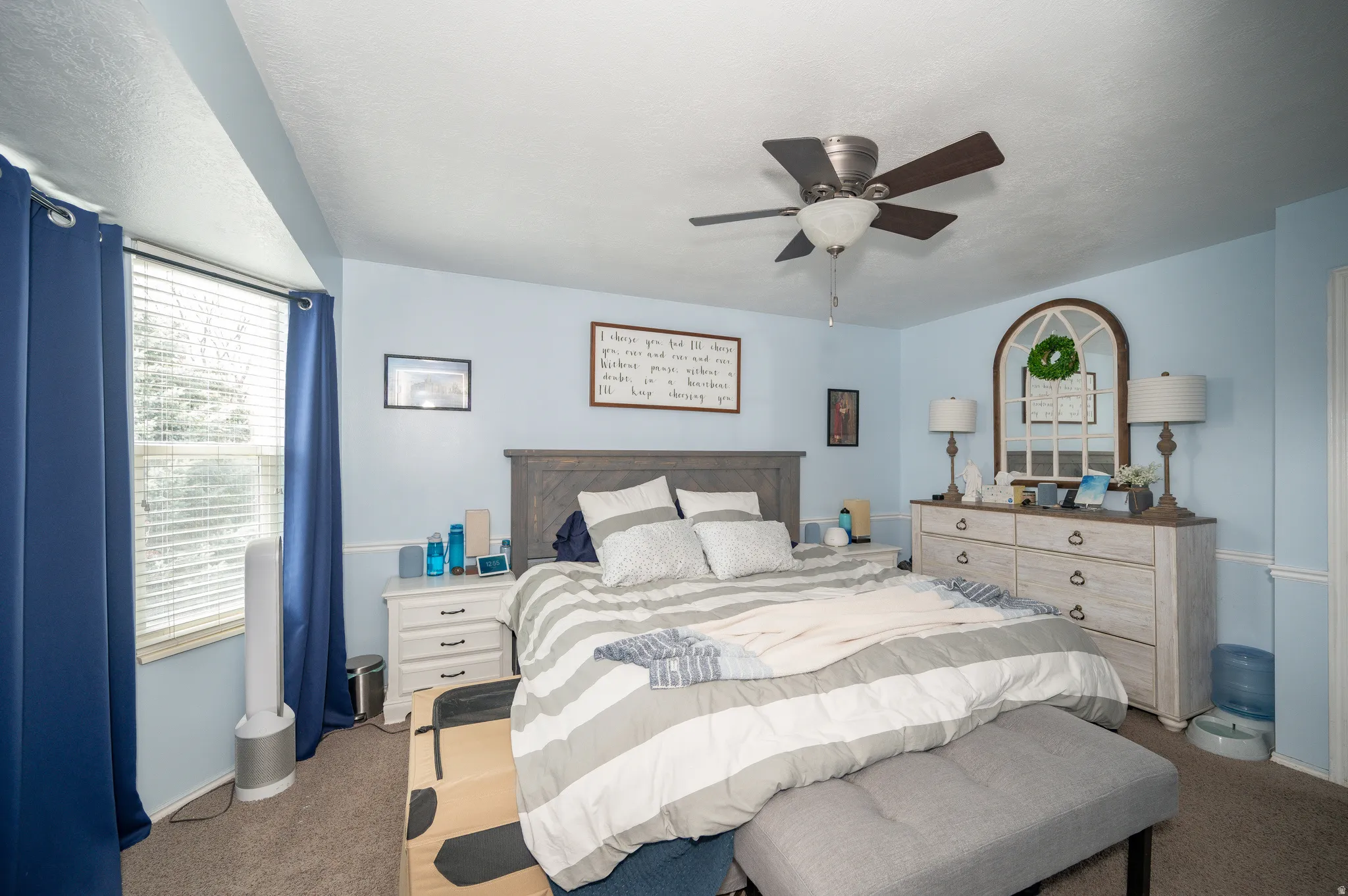 Bedroom featuring a ceiling fan with integrated lighting, a window with blinds, and carpeted flooring