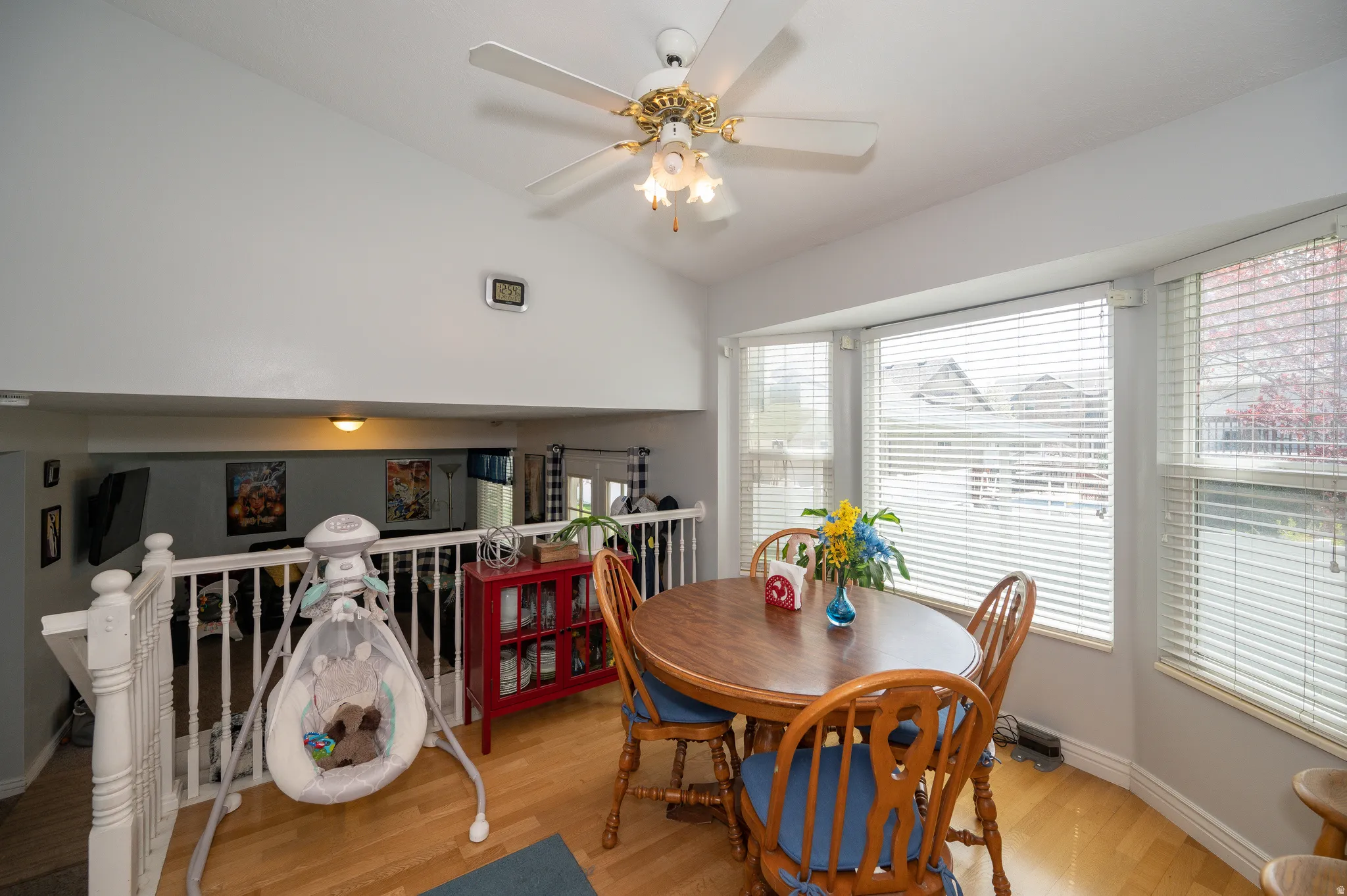 Dining area featuring wood-finish flooring and a bay window with blinds