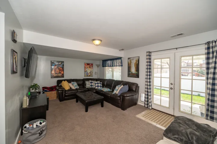 Versatile lower-level living space featuring neutral carpet flooring and light gray walls