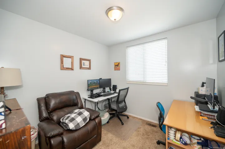 Room with light gray walls, a window with blinds, and a built-in overhead light fixture