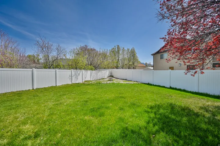 Expansive green lawn area surrounded by a privacy fence