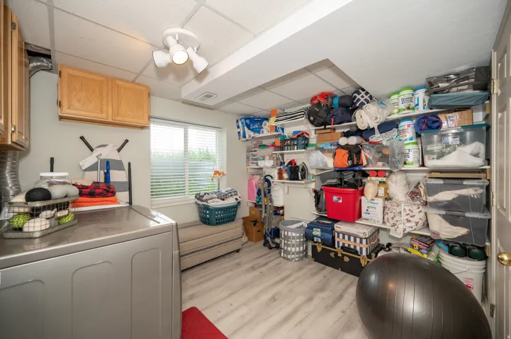 Utility room featuring light wood-finish flooring and a drop ceiling