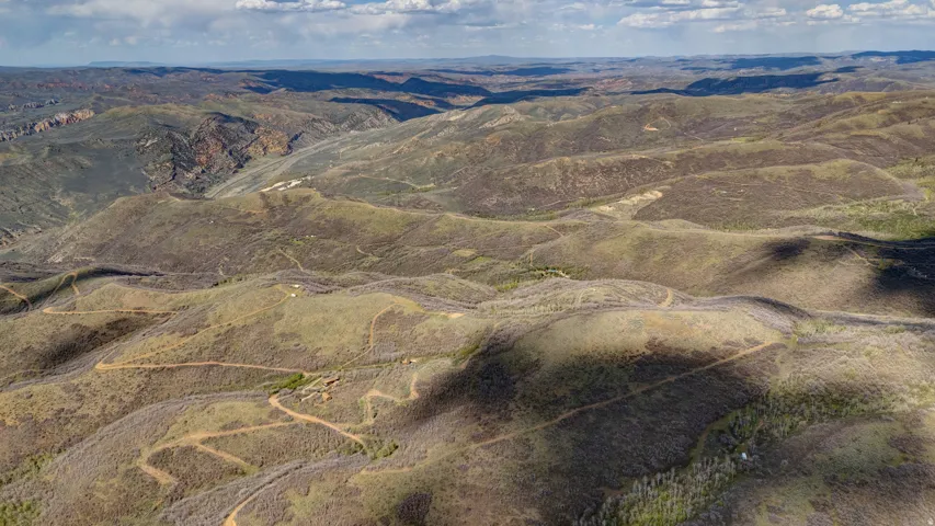 Expansive mountainous terrain featuring natural vegetation and visible winding pathways