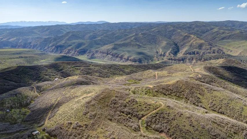 Expansive mountainous terrain featuring diverse vegetation and prominent ridgelines