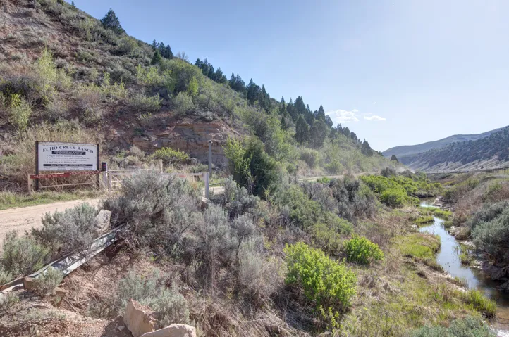 Expansive natural landscape with a prominent "Echo Creek Ranch" sign and gated entrance