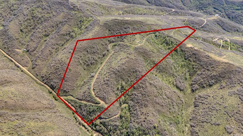 Expansive undeveloped land parcel outlined in red, featuring varied topography and natural vegetation