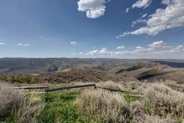 Expansive mountain landscape featuring rolling hills and distant valleys