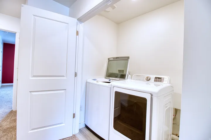 Dedicated laundry area featuring a white top-load washer and front-load dryer
