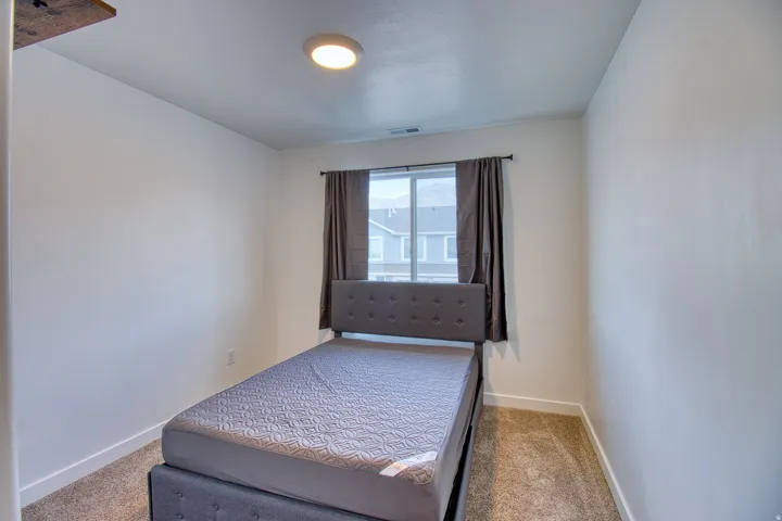 Carpeted room with a window, contemporary light fixture, and white baseboards