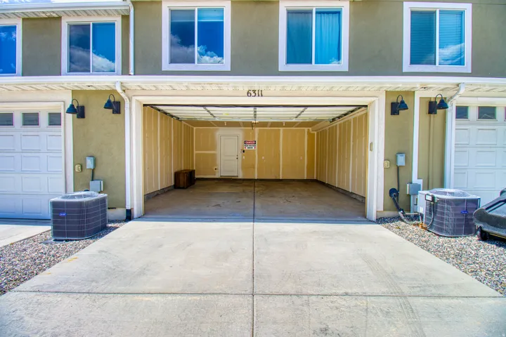 Two-car garage with a concrete driveway and exposed stud walls