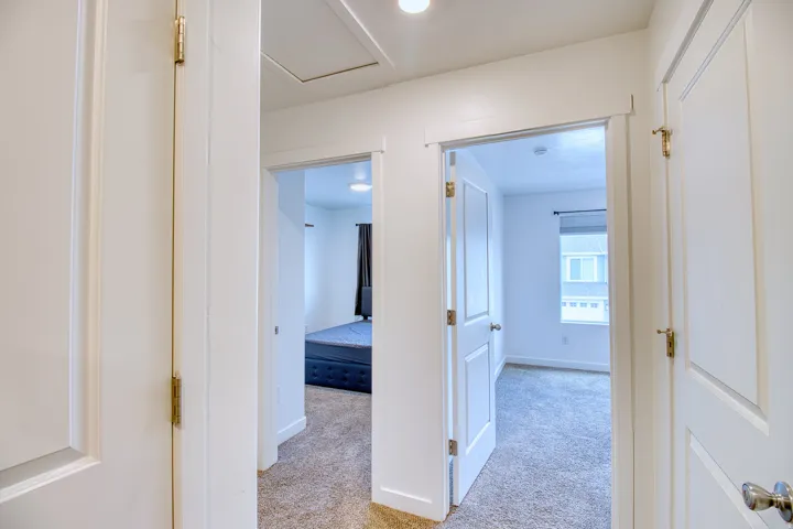 Hallway featuring light-colored carpet flooring and white walls