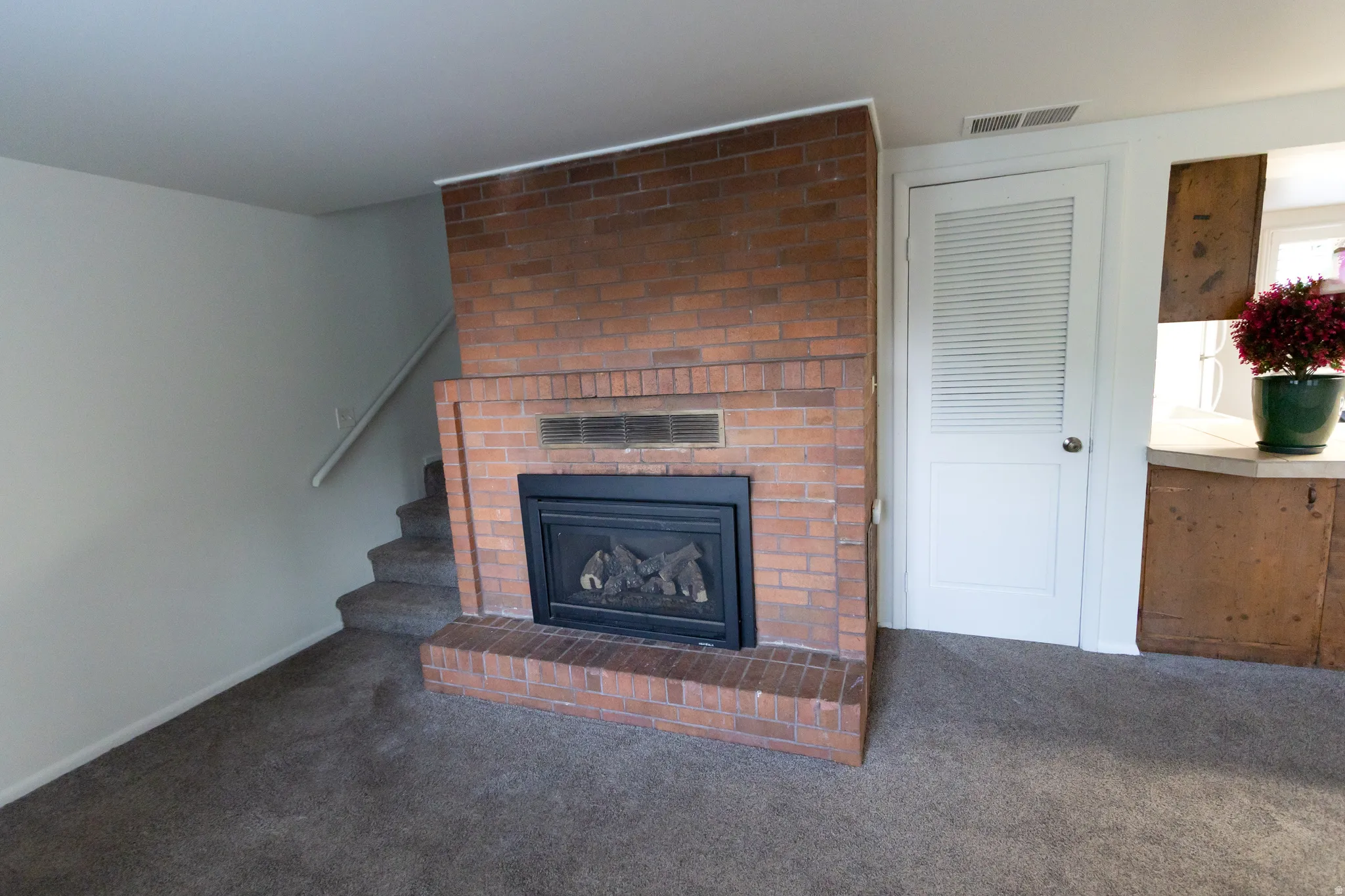 Brick-faced fireplace with a black insert