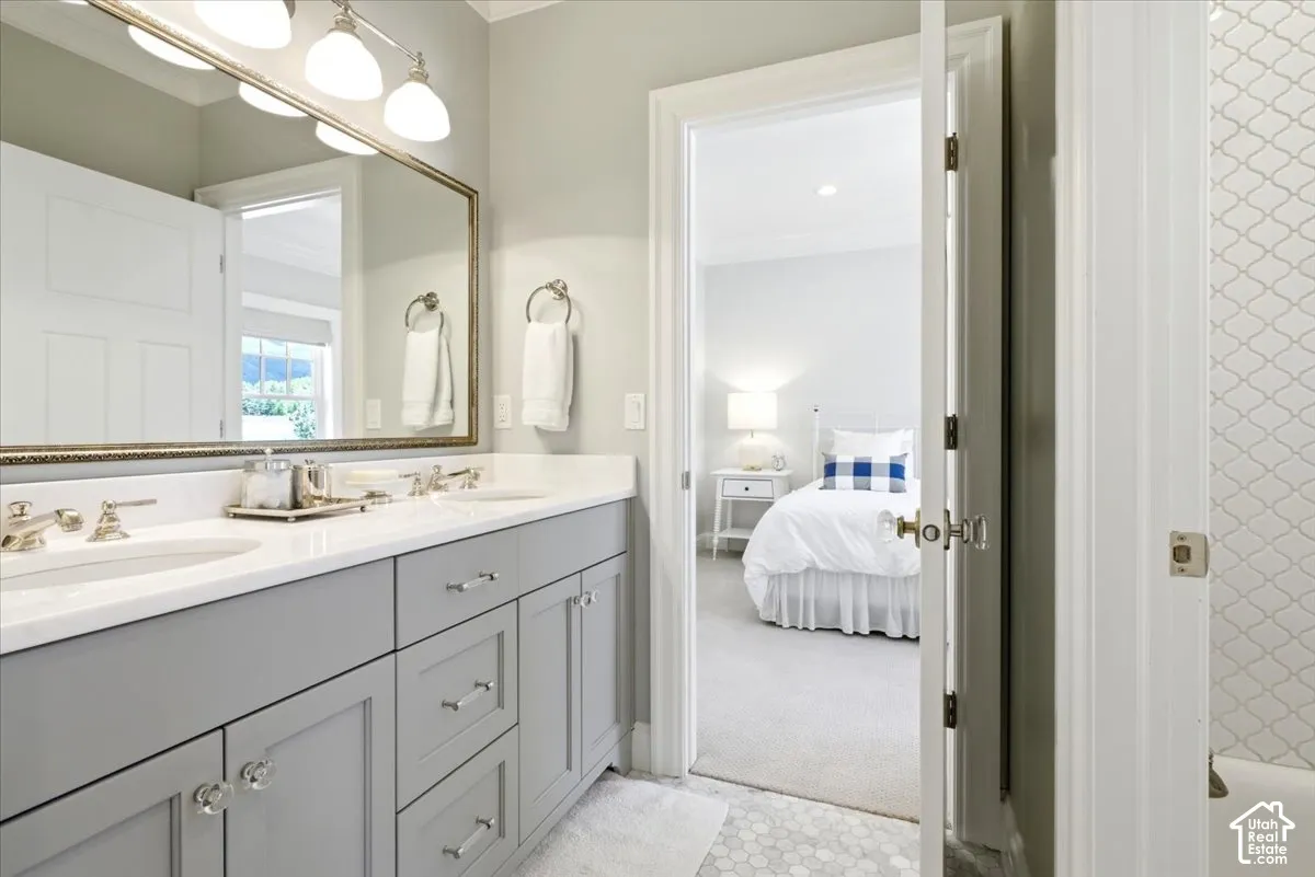 Double vanity featuring gray cabinetry, polished chrome hardware, and a white countertop