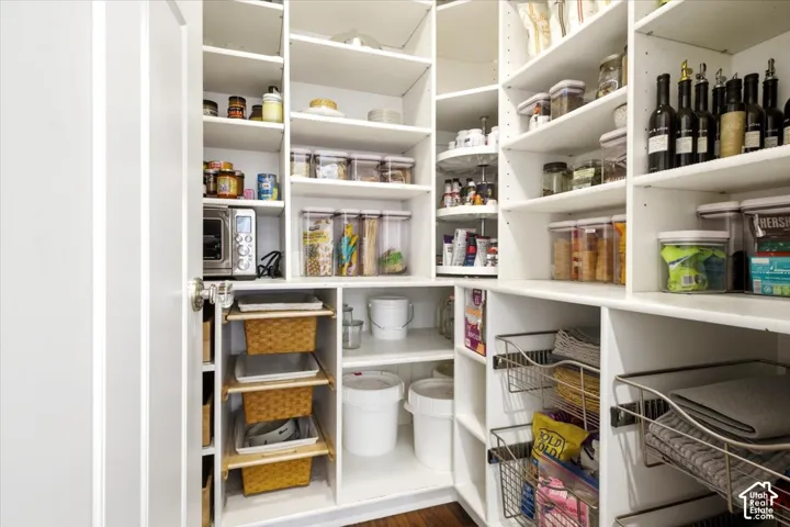 Built-in pantry system featuring white shelving, integrated wire baskets, pull-out storage, and a corner lazy Susan