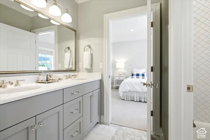 Double vanity featuring gray cabinetry, polished chrome hardware, and a white countertop