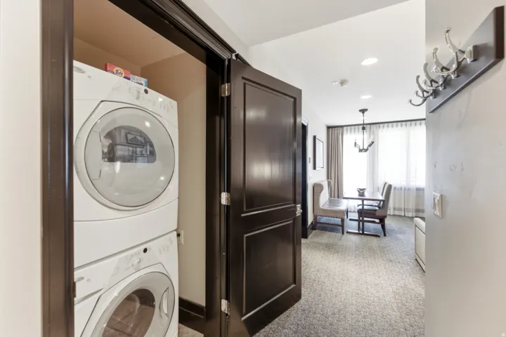 Recessed laundry closet featuring stacked front-load appliances