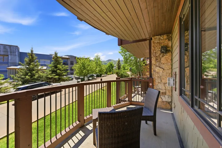 Private balcony with stone accent wall and natural wood ceiling