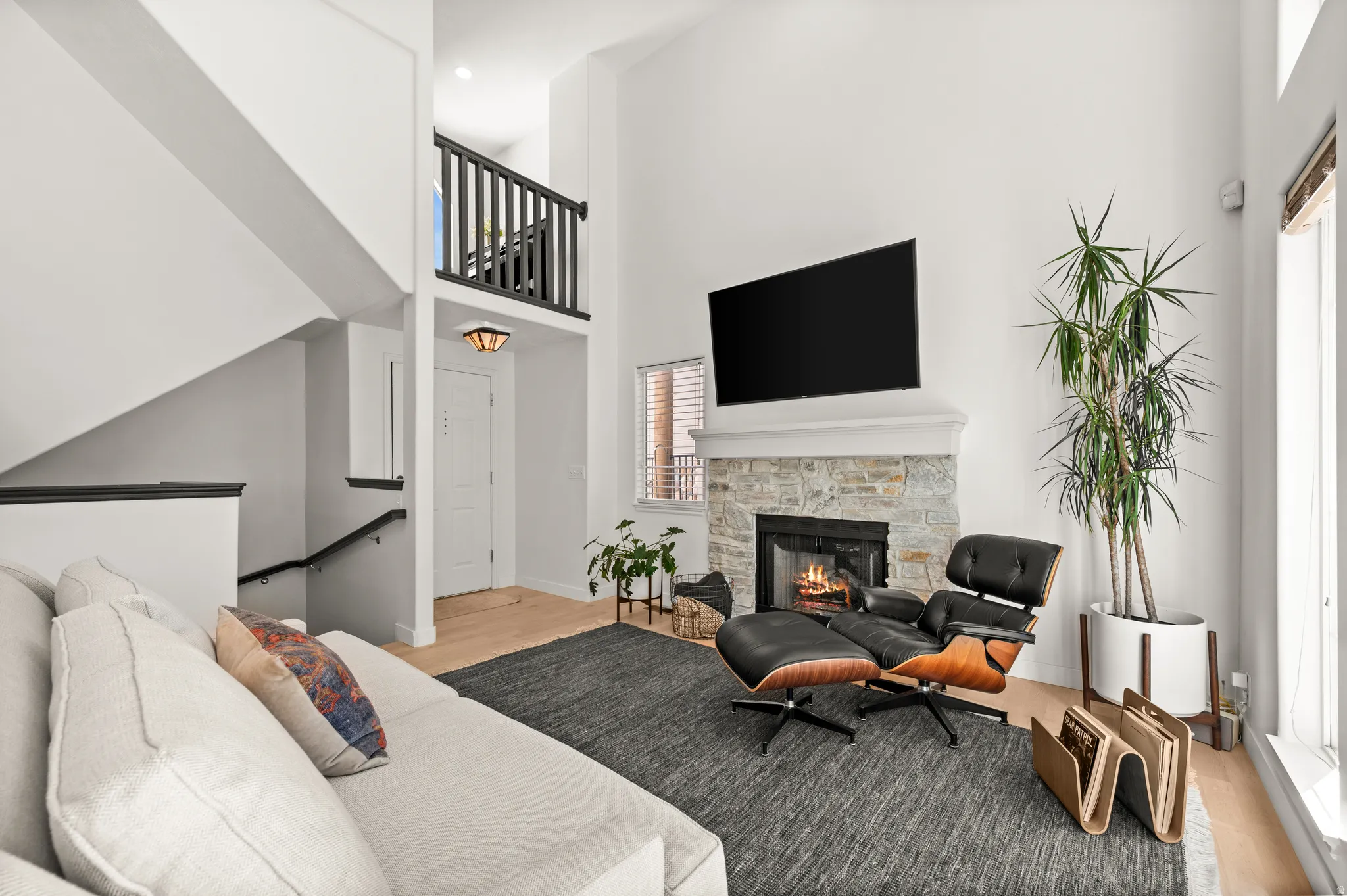 Living area featuring a stone-clad fireplace with mantel, gas log insert and vaulted ceilings