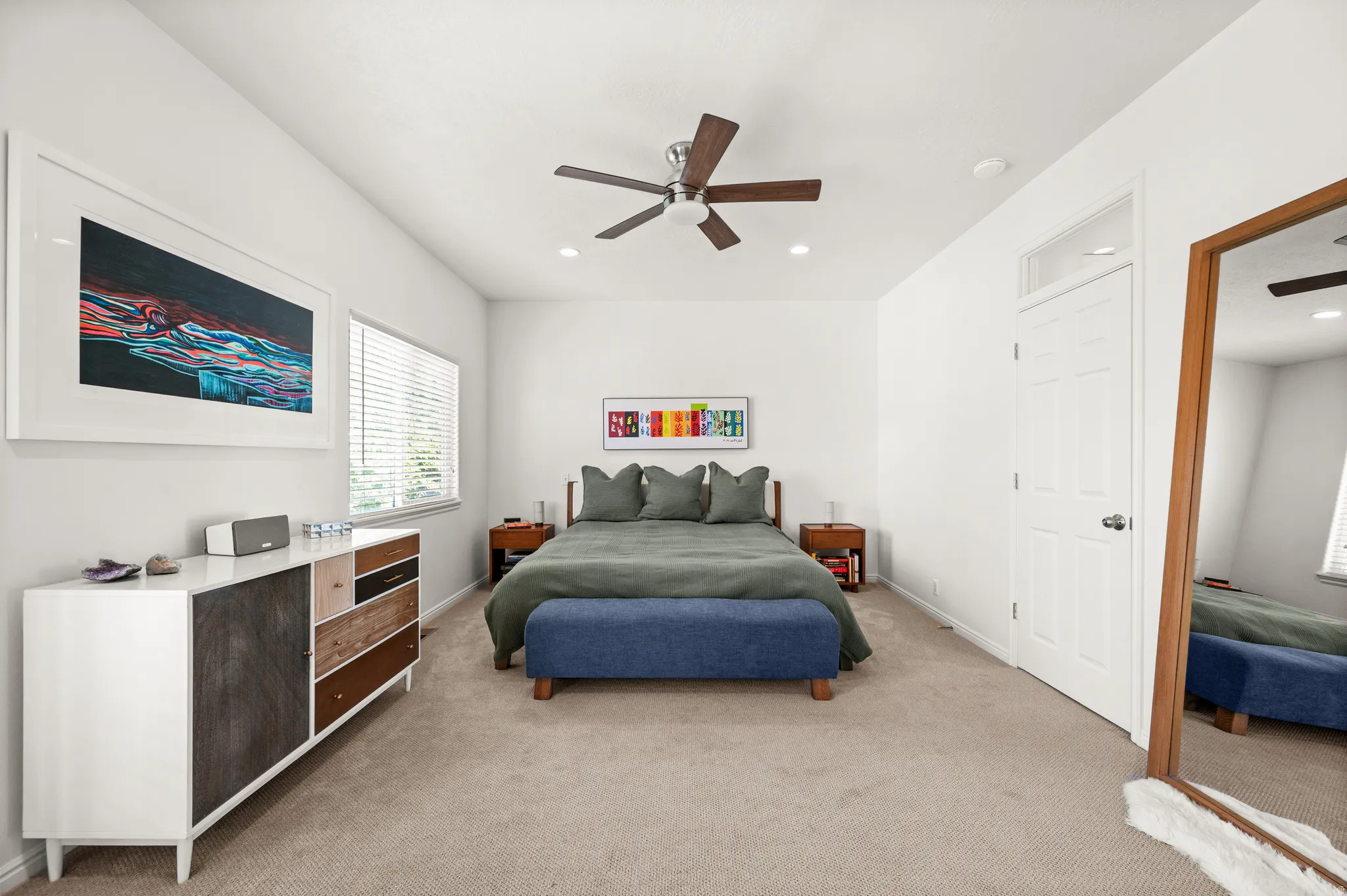 Spacious primary bedroom featuring neutral carpeting, a ceiling fan with recessed lighting and northern light