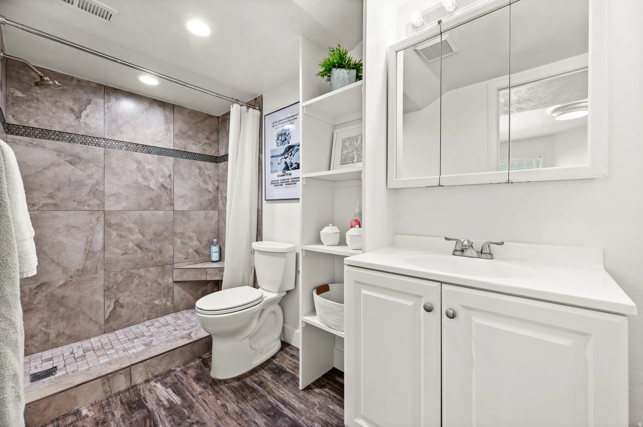 3/4 bathroom featuring a shower with large format tile, storage shelving and mirror with storage