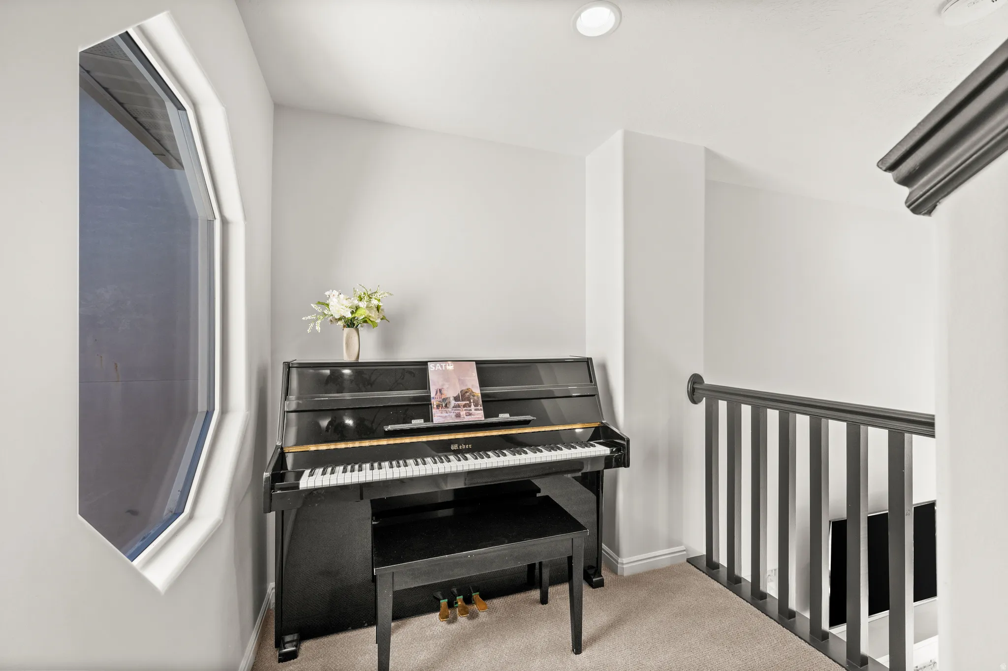 Bright landing area with an angular window, recessed lighting, and carpeted flooring
