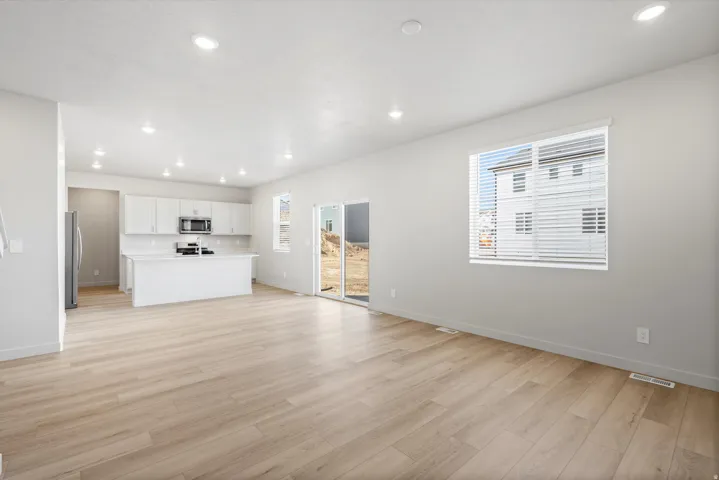 Open-concept living area with wood-finish flooring and recessed lighting