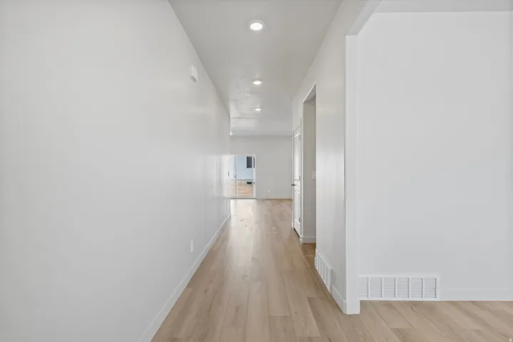 Entryway featuring wood-finish flooring, recessed lighting, and white walls throughout