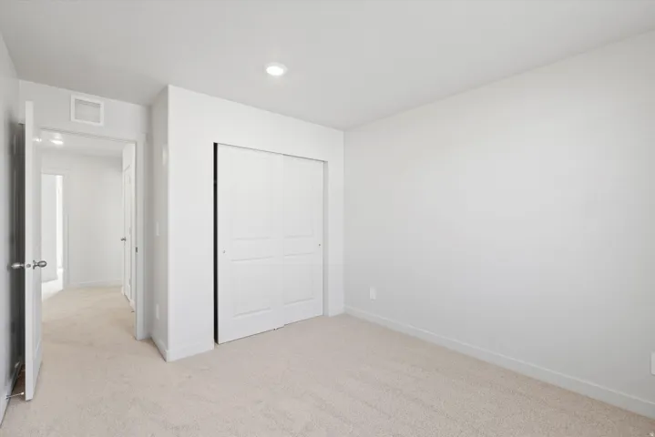 Bedroom with light-toned carpet flooring and white walls