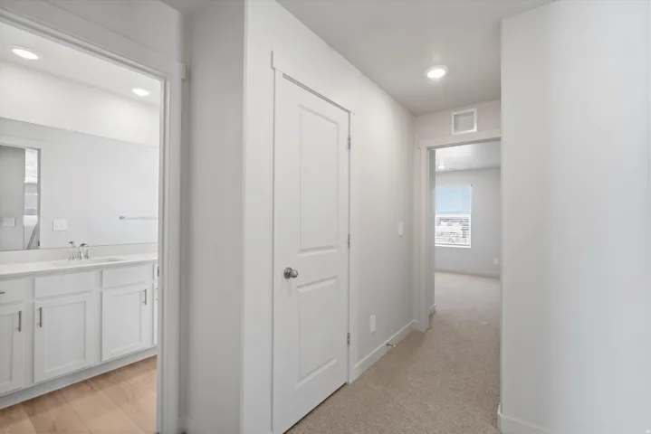 Hallway featuring neutral carpet flooring and recessed lighting