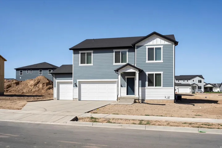 Two-story residence featuring blue horizontal siding with white trim, a dark grey asphalt shingle roof, and a covered entry