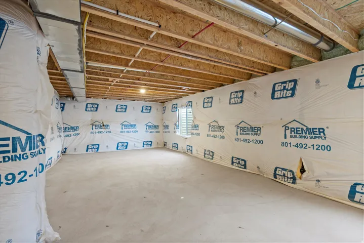 Unfinished lower level featuring exposed wood joists and subflooring