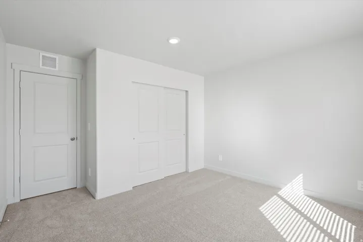 Neutral tone wall finish and plush carpet flooring throughout
