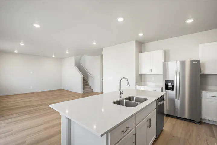 Kitchen island featuring a stainless steel double basin sink and a chrome gooseneck faucet