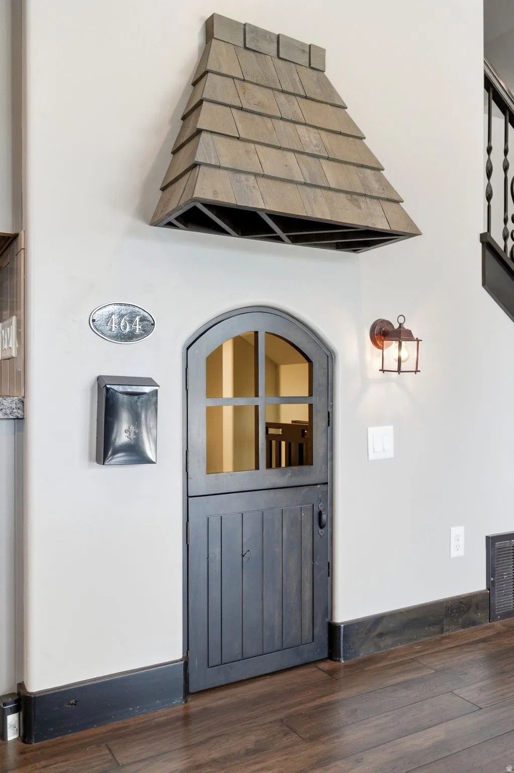 Arched wood-finish Dutch door with upper window panes