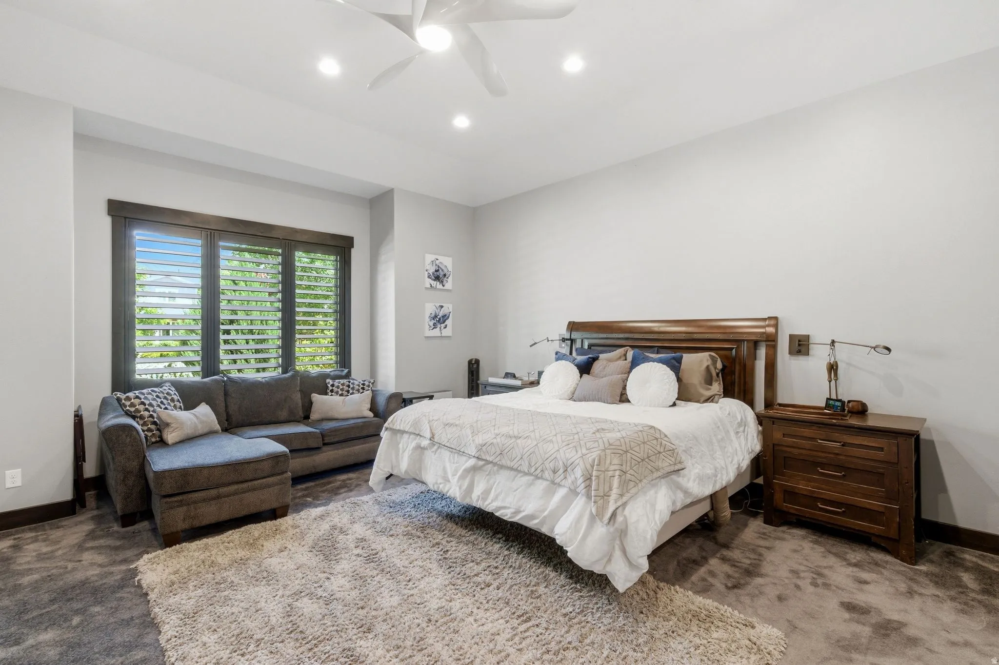 Spacious room featuring a large window with plantation shutters, recessed lighting, and a ceiling fan
