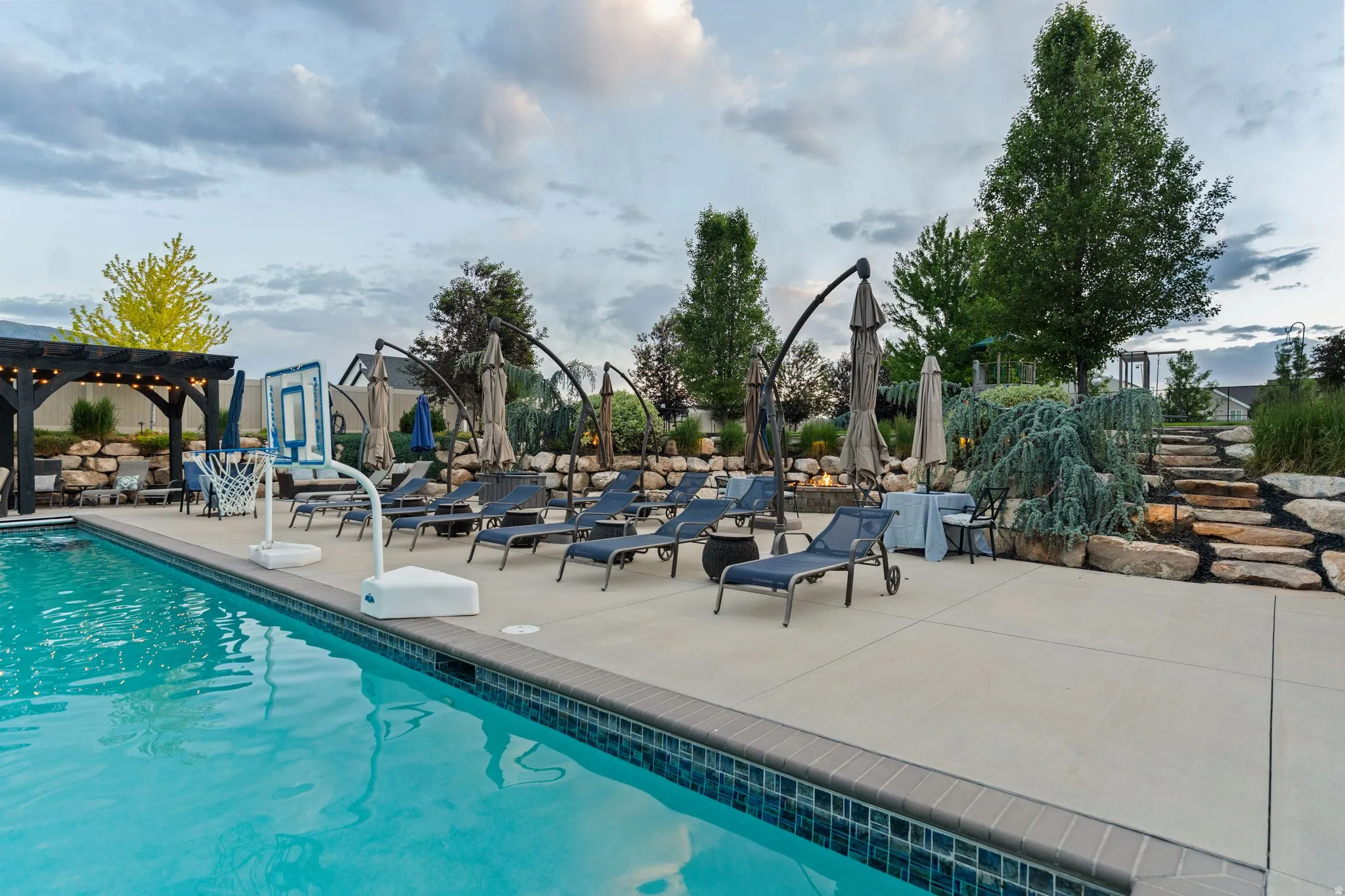 Outdoor swimming pool featuring a tiled edge and surrounding concrete patio
