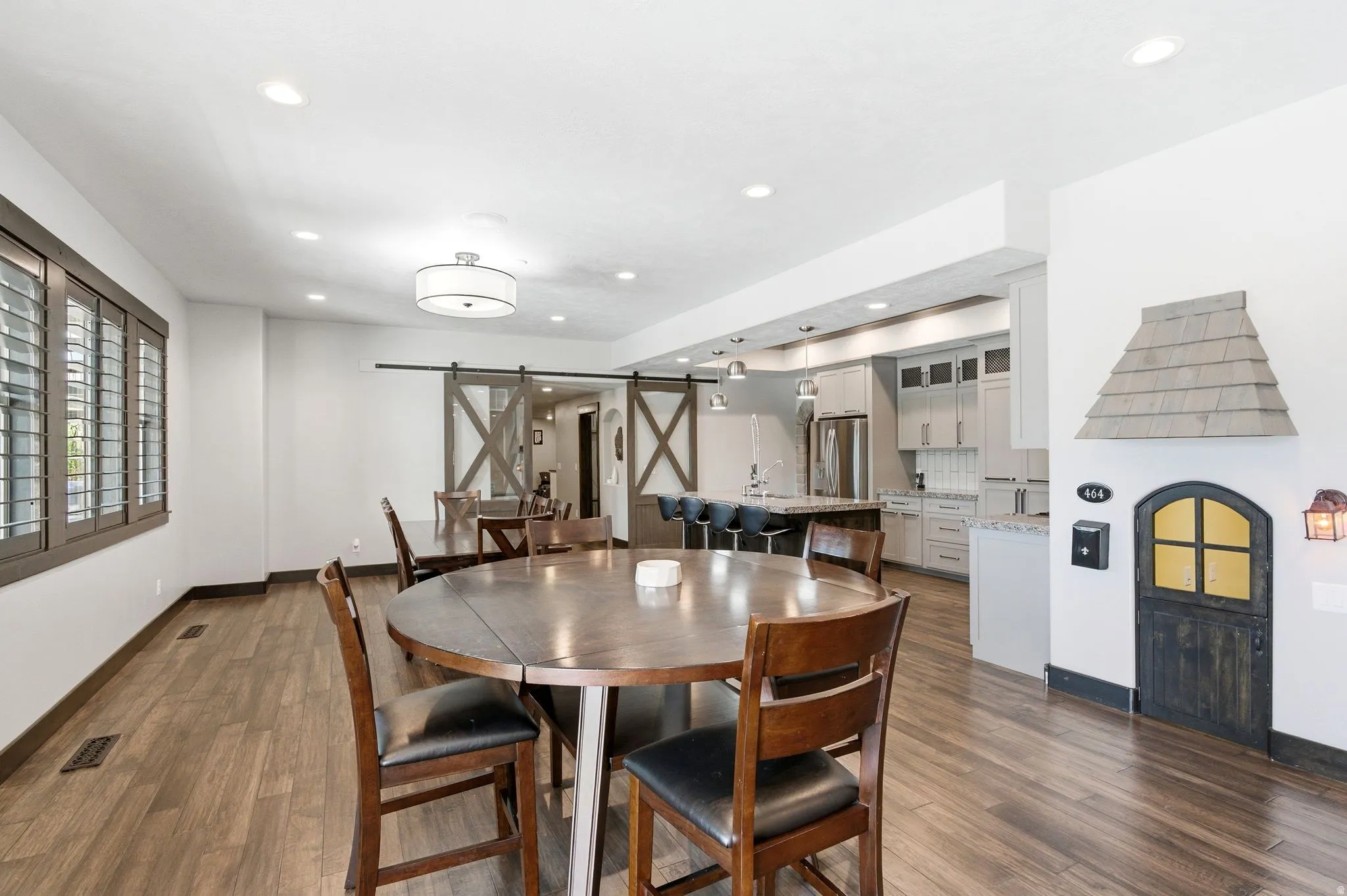 Open-concept living space featuring wood-finish flooring, recessed lighting, and a modern kitchen