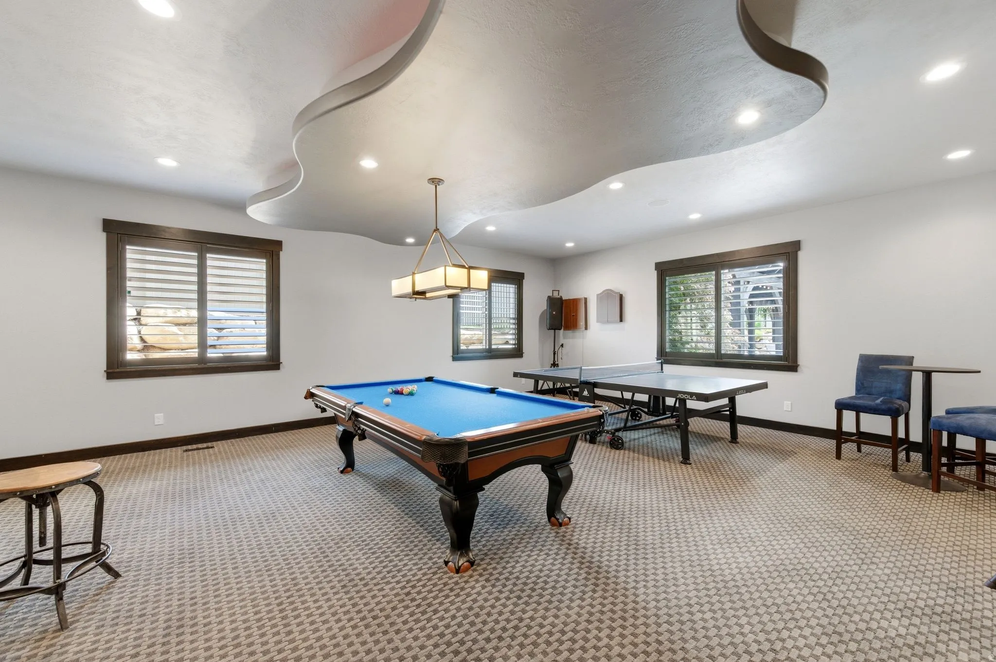Entertainment space featuring a custom ceiling design with recessed lighting
