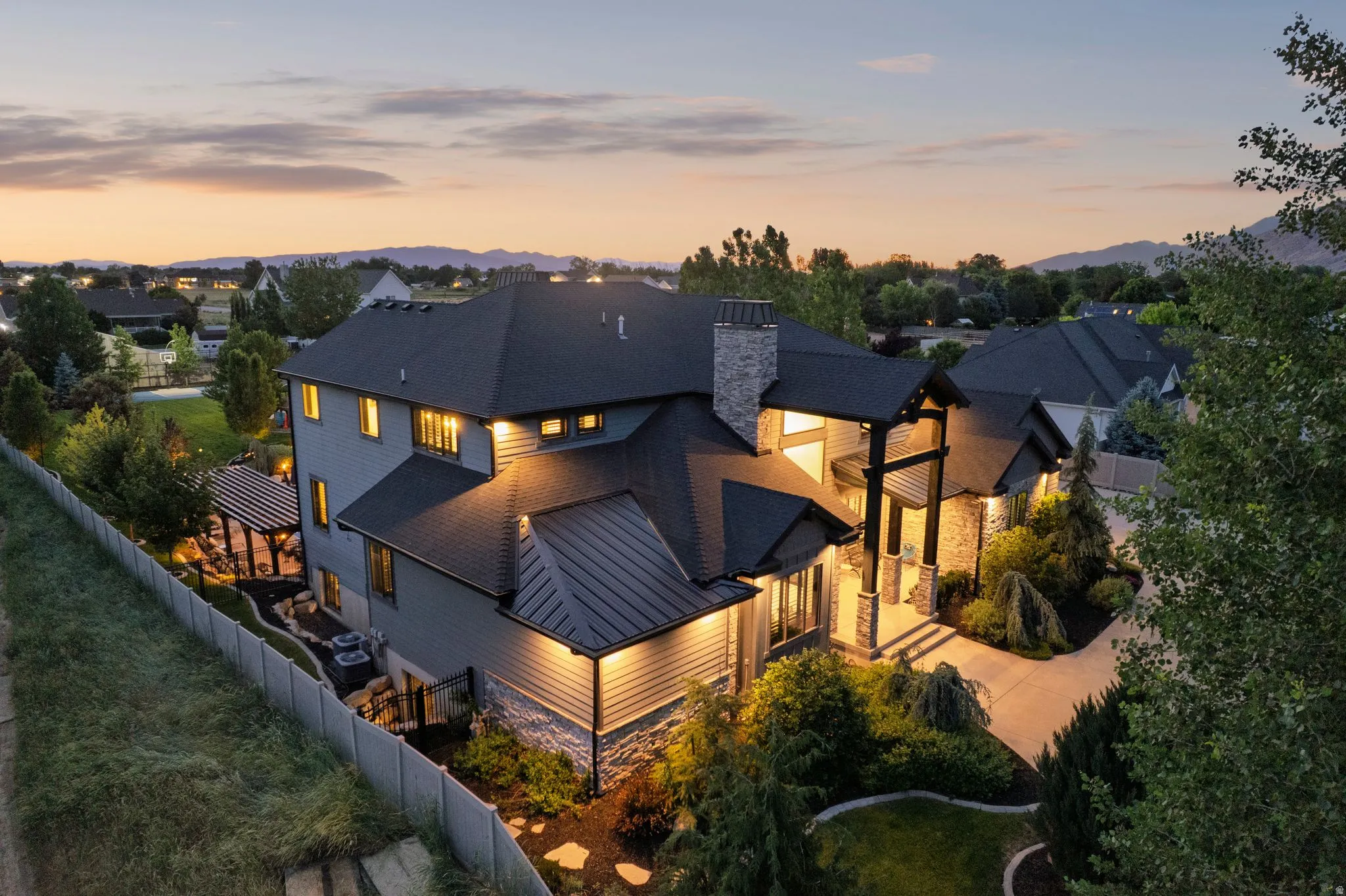 Grand exterior featuring stone accents, a multi-gabled roofline, and a prominent chimney