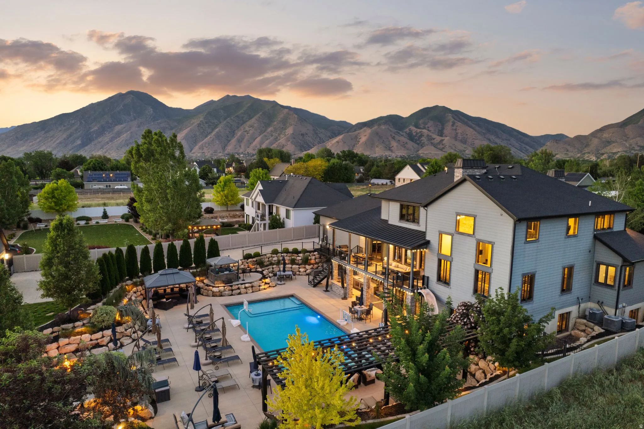 Expansive multi-level backyard featuring a swimming pool, integrated spa, and multiple patio areas