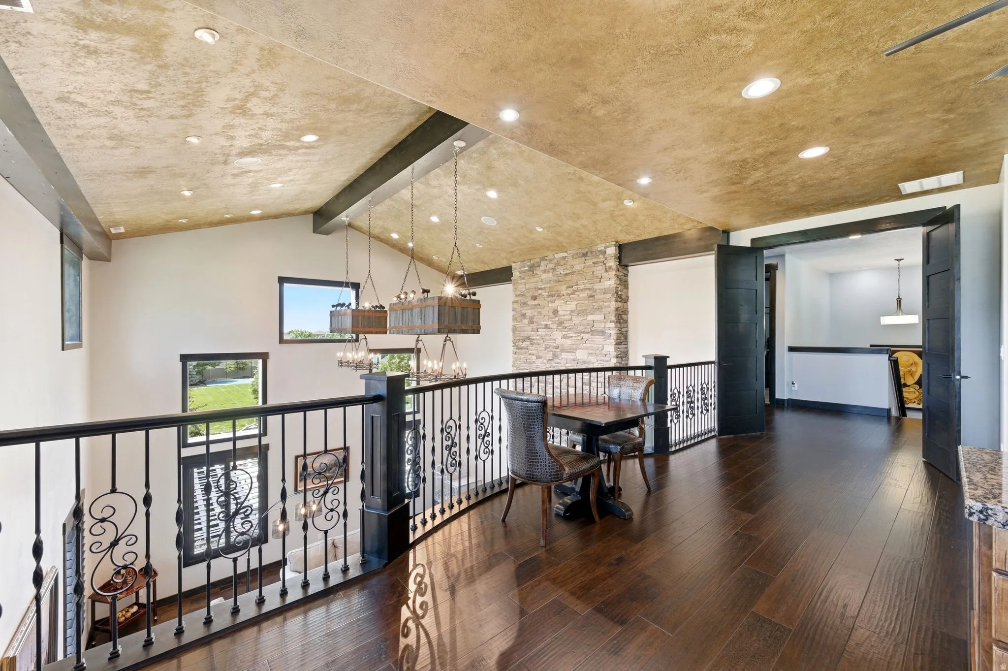 Mezzanine level featuring wood-finish flooring and a stone accent wall