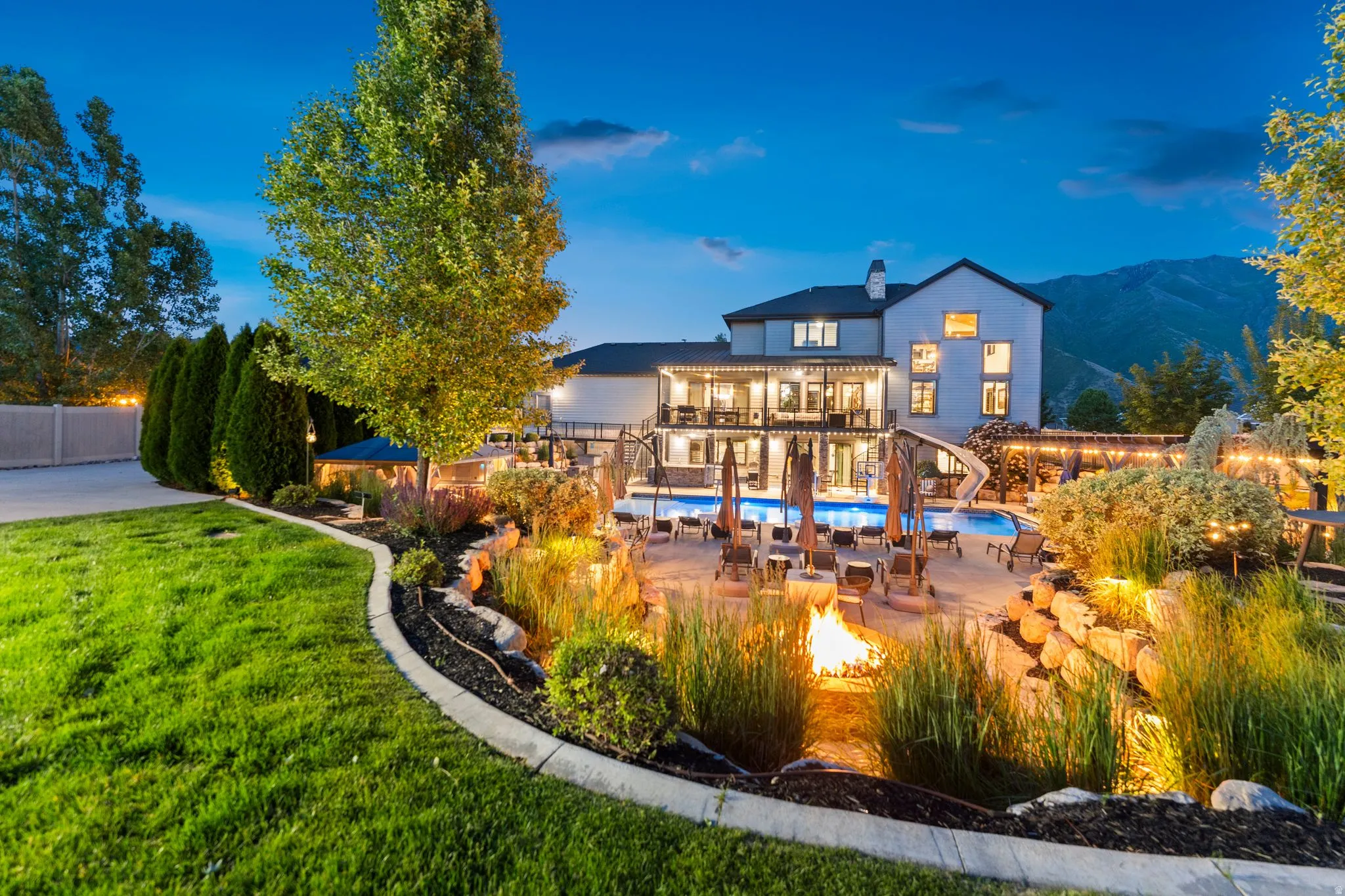 Expansive backyard featuring a large swimming pool, surrounding patio, and dedicated lounge areas