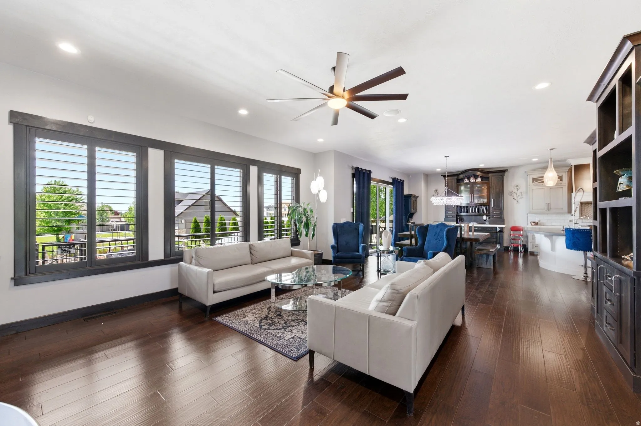 Open-concept living space featuring wood-finish flooring, recessed lighting, and a ceiling fan