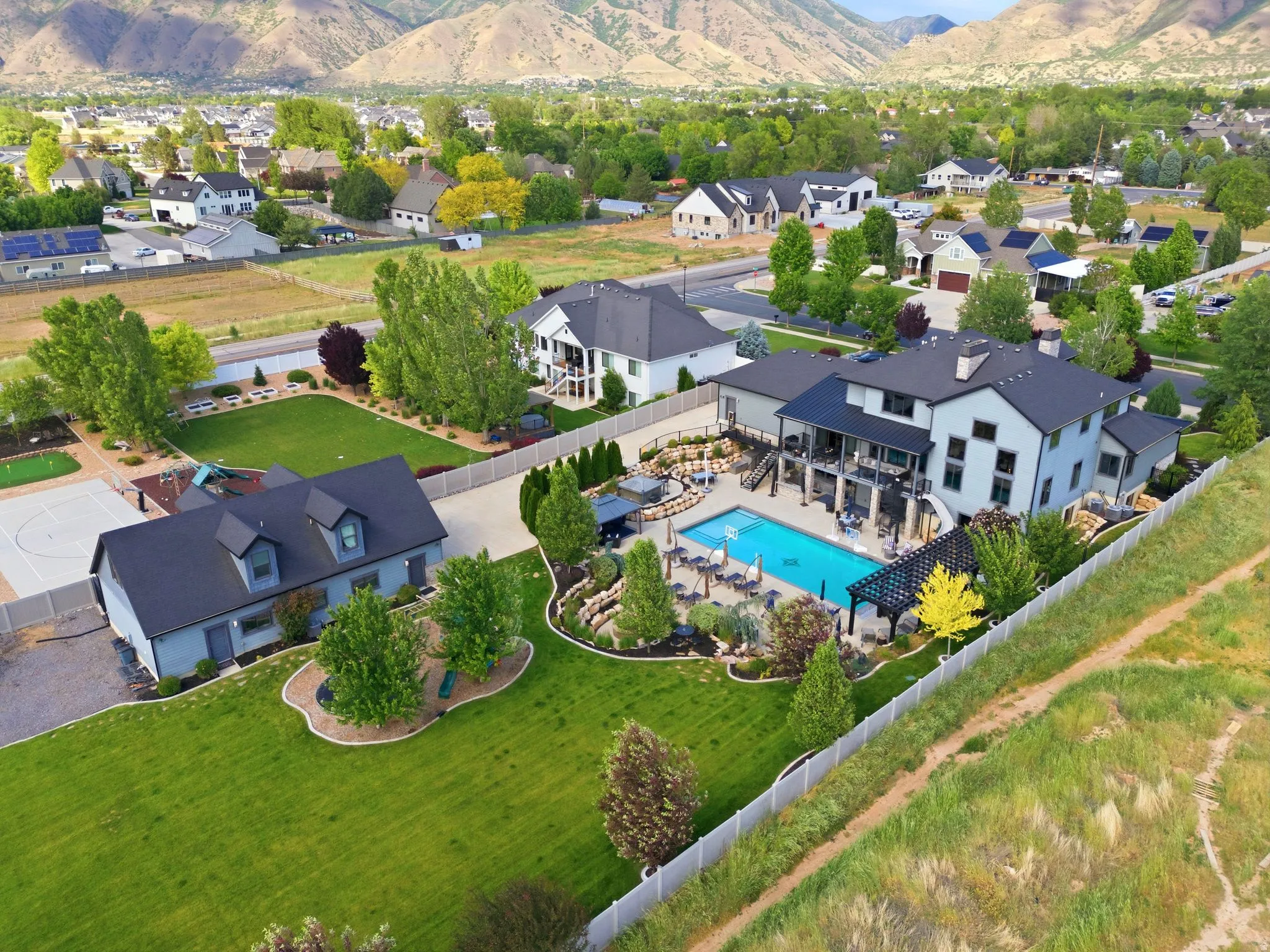 Expansive property featuring a large swimming pool, multi-level patio areas, and a separate detached structure