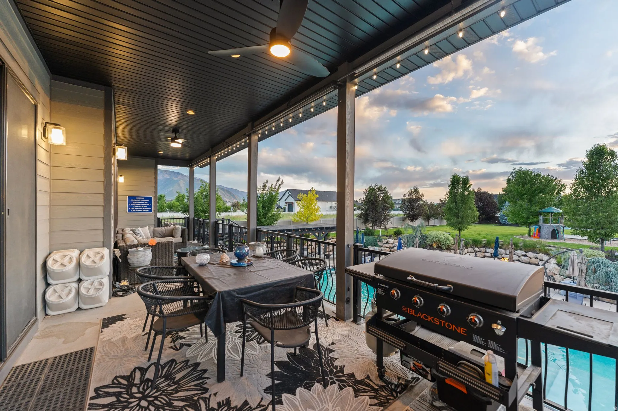 Covered outdoor patio featuring a slatted ceiling with recessed lighting and ceiling fans